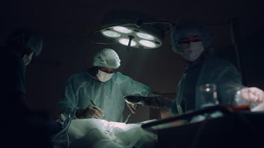 医生团队执行外科手术操作黑暗医院操作房间